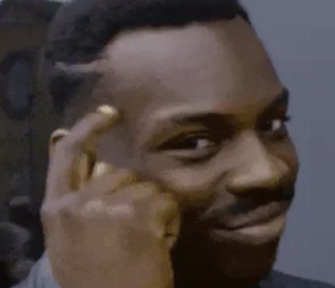 A meme image of a young man pointing at his head with a finger while making a subtle, knowing expression.