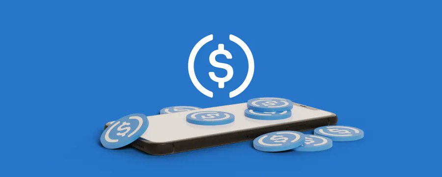 In the image, a cell phone is lying face up with five blue coins stacked on top of each other next to it. The text in the caption indicates that these coins have been minted using Solana's USDC. This information implies that the coins were created through a Bitcoin-based transaction involving USDC or another cryptocurrency like Solana.