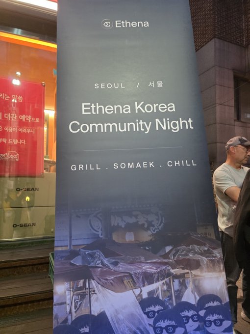 A banner for the 'Ethena Korea Community Night' event in Seoul, advertising 'GRILL . SOMAEK . CHILL', with people standing nearby.