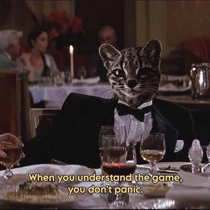 A cat wearing a tuxedo sits at a formal dinner table with the caption "When you understand the game, you don't panic." The image humorously conveys composure and confidence despite the chaotic boasts in the post, suggesting the speaker sees themselves as composed and in control while dismissing others' attempts at manipulation.