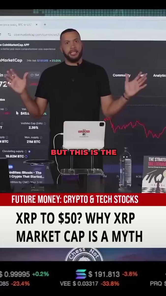The image features a man standing behind a laptop computer with his arms raised in an excited or enthusiastic manner, possibly giving a presentation related to investing in cryptocurrency markets. He appears to be delivering a speech about "XRP" (XRP) and its potential for growth, as suggested by the text provided. The setting suggests that this could either be a conference or a seminar where the man is sharing insights with an audience.