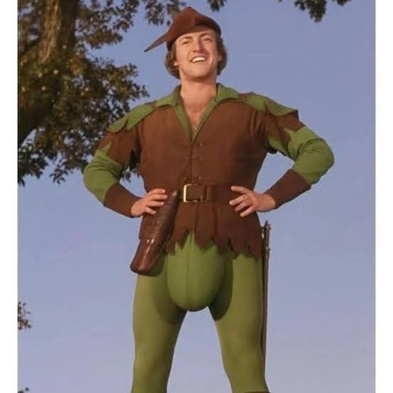 The image shows a smiling man dressed as Robin Hood in a classic brown and green tunic with feathered cap, hands on hips, posing in a campy promotional-style photo that visually matches the post's "May the Hood Be With You" wordplay about the cryptocurrency $TH.