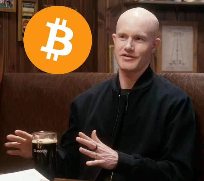 A bald man in a black jacket sits in a pub-style setting with a Guinness beer in front of him, gesturing while speaking, with a Bitcoin logo overlaid in the top-left corner—illustrating Coinbase CEO Brian Armstrong's quote about using Bitcoin as collateral for a home down payment.