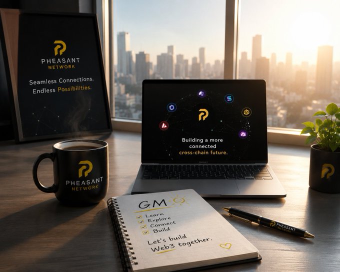 A bright workspace scene features a laptop displaying "Building a more connected cross-chain future" alongside a notebook with a "GM" checklist (Learn, Explore, Connect, Build) and a branded "Pheasant Network" coffee mug, all set against a sunlit city skyline. The image visually reinforces the post's morning greeting and its theme of seamless cross-chain experiences, tying together the Web3/DeFi lifestyle of curiosity, connection, and community.