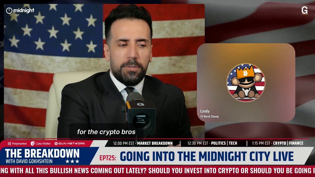 The image shows a man wearing a suit sitting at a desk with a computer screen displaying a news article about cryptocurrency. The headline of the article reads "EP25 Going into the Midnight City Live", which suggests that the man might be discussing or reporting on the topic of cryptocurrency and its impact on society, given his professional attire and the context provided by the image.