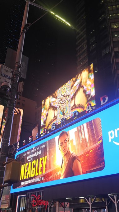 A nighttime photograph of a large Broadway billboard displaying 'NEAGLEY' and 'prime original' for a Disney+ premiere on September 16, with the number '1540 BROADWAY' visible on the building facade.