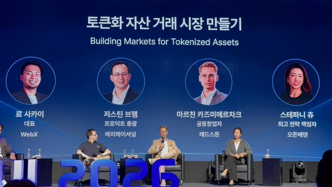 A panel discussion titled 'Building Markets for Tokenized Assets' (토큰화 자산 거래 시장 만들기) featuring speakers from WebX, Base, Mastercard, and OpenSea seated on stage.