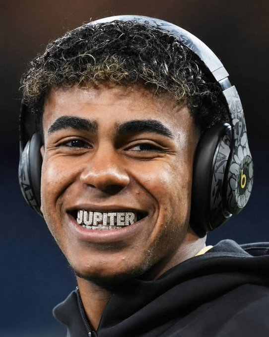 The image shows a young man wearing Beats headphones, smiling to reveal grills that spell "JUPITER" on his teeth. The post's wordplay about "locking the F in" for the Spain vs. Austria match likely references his confident, committed expression, tying into the note that Spain is the #3 favorite to win it all at 11%.