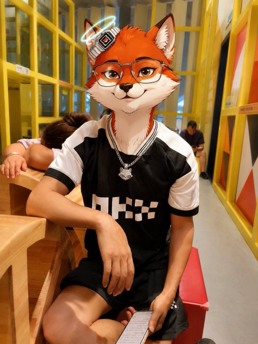 A cosplayer wearing an orange fox mask, glasses, a silver chain, and a black and white shirt sits on a stool in a hallway with yellow-framed windows.