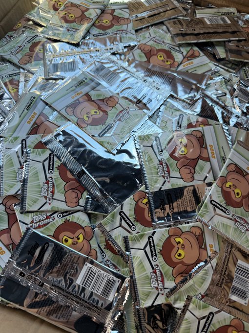 A large pile of stacked instant coffee packets featuring a cartoon bear mascot and the brand name 'Kopi Luwak' with Indonesian text 'Tetas Chromo'.