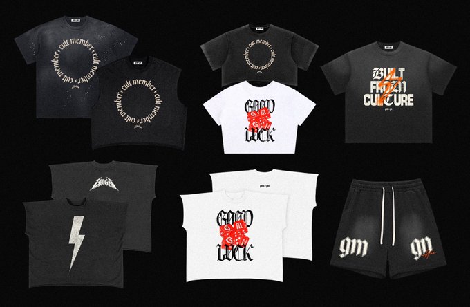 Collection of clothing merchandise including black and white t-shirts and shorts with various designs such as "Good Luck," "Built From Culture," and "gm" with lightning bolt and gothic-style graphics.