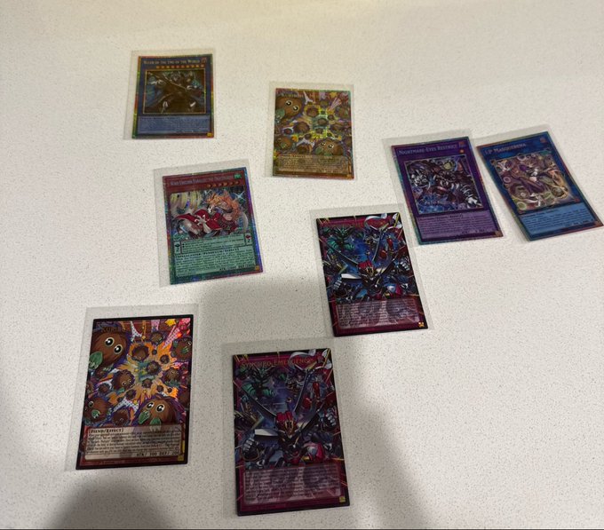 A scattered collection of holographic Yu-Gi-Oh! trading cards, including "Number 86: Heroic Champion - Rhongomyd," "Abyss Actor - Evil Heel," "LP Modifier," "Number C101: Silent Honor DARK," and others, laid out on a white surface for a "coded" pull showcase with @slabcash.