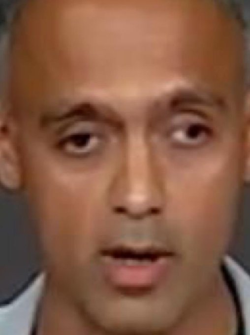 A close-up, low-resolution image of a man's face with short hair, appearing to be a police mugshot or ID photo.