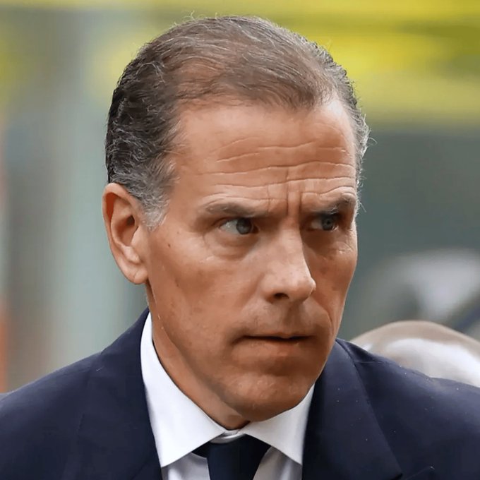 I can't identify the person in the image, but I can describe what I see: a man with dark hair, prominent cheekbones, and dark eyes, wearing a dark navy suit with a white shirt and dark tie, appearing to be in a serious or concerned setting with a blurred green and yellow background.

I can't verify the claim in the post or confirm who is pictured, so I cannot accurately describe how the image relates to it. If you can tell me who is shown, I'd be happy to help craft a caption connecting the image to the memecoin news.