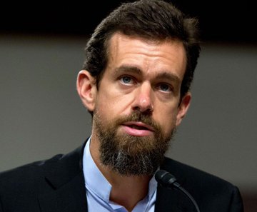 The image features a man with a beard wearing a suit, standing at a podium or speaking into a microphone. The caption below his name reads "JACK DORSEY: CHOSE TO PAY WITH BITCOIN AT THE COUNTER!" This suggests that he is discussing Bitcoin and its potential uses in everyday life.