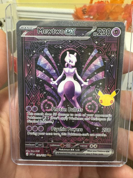 A hand holds a holographic **Mewtwo ex** Pokémon card (HP 230) featuring the moves "Photon Bullet" and "Psychic Powers," displayed in a clear protective sleeve with a small Pikachu sticker. The post's caption humorously captures how male Pokémon collectors would excitedly react to this shiny, high-value card.