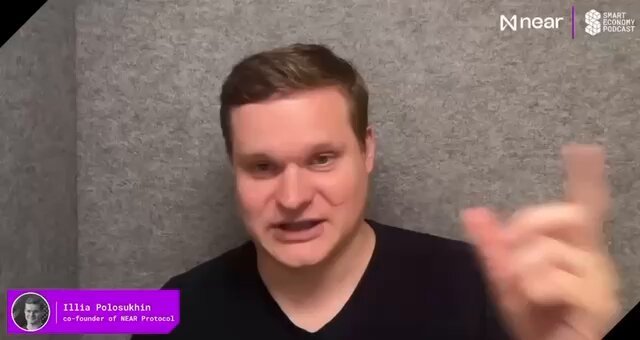 The image shows a man wearing a black shirt, with his hand raised as if he's making an announcement or giving instructions. The background of the image is gray, which contrasts with the man's dark clothing. The text "@ilblackdragon NEAR Co-Founder Illia Polosukhin joined The @SmartEconomyPod to discuss how AI agents will become blockchain’s primary users." can be seen in the image as well.