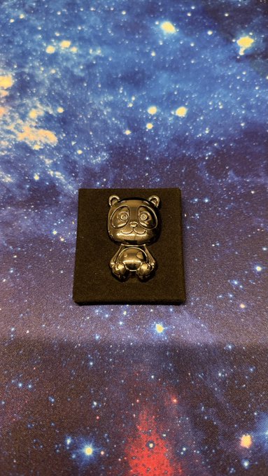 A small black Maneki-neko (lucky cat) figurine sits on a square base against a starry galaxy backdrop.