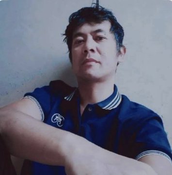 A man with dark, tousled hair wearing a navy blue polo shirt featuring a small circular emblem on the chest poses against a plain, light-colored wall with his arms crossed in a relaxed, contemplative stance. The image appears to be associated with Dr. Nicolas Kokkalis, a Pi Network co-founder referenced in the accompanying post about new SoloHost applications.