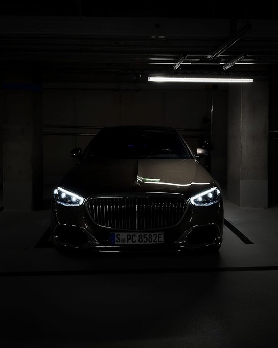 The image features a dark car with its headlights on, parked inside a garage or under a tunnel. The car has a license plate that reads "SPC 865ZE". The scene suggests that the car might be used for security purposes, as it is equipped with advanced technology to ensure its safety and security. This could include features like keyless entry systems, GPS tracking, or even an alarm system. The use of advanced technology in vehicles can help protect them from theft or vandalism, making them more secure and reliable modes of transportation.
