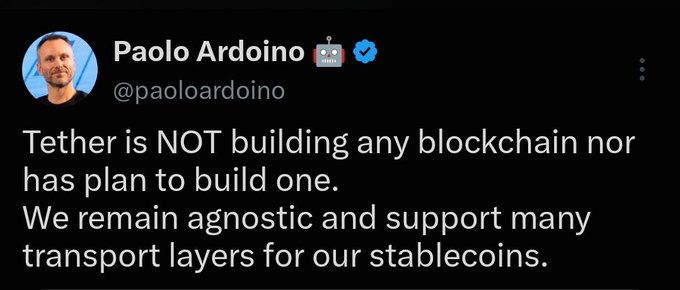 A screenshot of a tweet from Paolo Ardoino (@paoloardoino), CEO of Tether, stating: "Tether is NOT building any blockchain nor has plan to build one. We remain agnostic and support many transport layers for our stablecoins." The image directly corresponds to the post by clarifying his public denial of Tether developing its own blockchain.