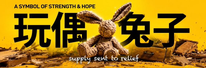 A promotional graphic features a stuffed bunny rabbit sitting among wooden debris against a yellow background, with large Chinese characters '玩偶兔子' (stuffed bunny) and the text 'A SYMBOL OF STRENGTH & HOPE' and 'supply sent to relief'.