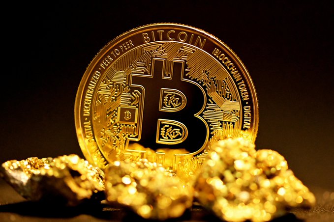 A golden physical Bitcoin token sits prominently against gold nuggets, with visible inscriptions "BITCOIN," "DECENTRALIZED PEER TO PEER," "DIGITAL," and "BLOCKCHAIN TOKEN." The imagery visually reinforces the post's optimistic Bernstein price projections by pairing Bitcoin with gold, evoking its potential as a store of value as it targets $150,000 by 2027 and a potential $1 million by 2033.