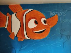 A hand-drawn illustration of Nemo the clownfish from 'Finding Nemo' with the text 'Nemo's home' written in the upper right corner against a blue underwater background.
