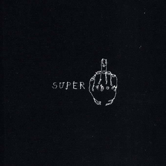 A dark, textured image featuring a white skeletal hand with its middle finger raised, positioned next to the word 'SUPER'.