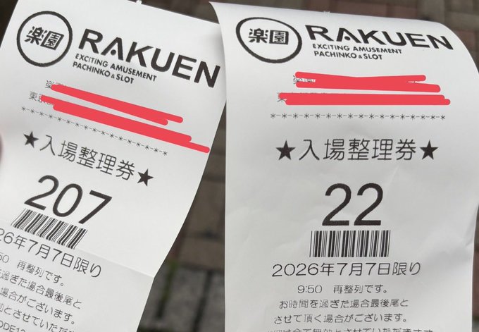 Two Japanese admission tickets (入場整理券) for 楽園 RAKUEN pachinko parlor, numbered 207 and 22, dated 2026年7月7日限り, with personal information redacted in pink.