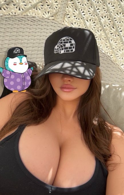A woman wearing a black leather cap with an igloo logo, with a cartoon penguin sticker applied over her eyes.