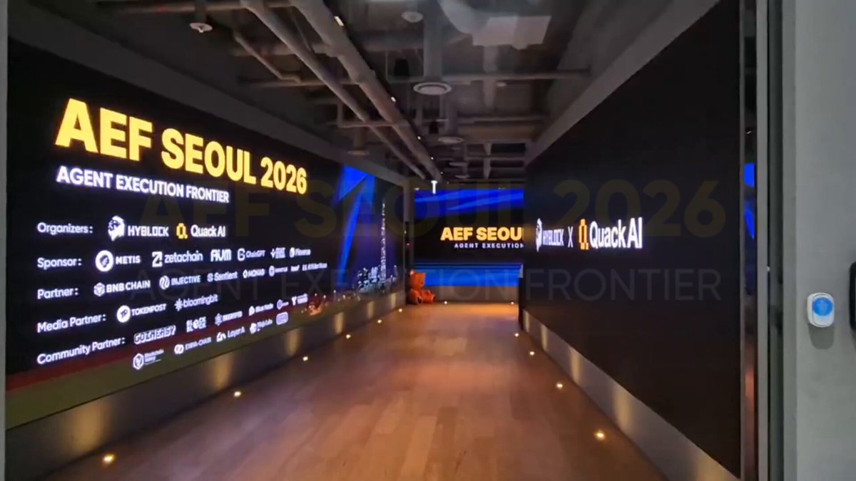 The image shows a large room with two rows of screens, one at each end, displaying information about an event called "AEF Seoul 2016". The screens are lit up, creating a bright atmosphere for the gathering. The text on the screens includes mentions of AI agents executing and executing on-chain markets, which suggests that this event is focused on the intersection of artificial intelligence and blockchain technology.