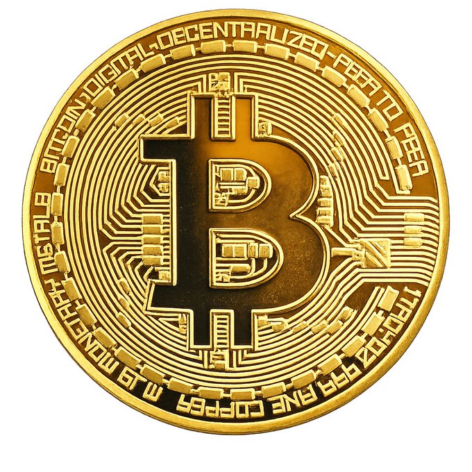 A gold Bitcoin commemorative coin with the 'B' symbol and text including 'BITCOIN DIGITAL DECENTRALIZED PEER TO PEER', 'MONETARY METALS', 'FINE COPPER', and 'TROY OZ 999 FINE COPPER'.