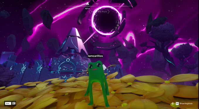 A green frog-like character named 'lamcariltos' stands on a bed of yellow bananas in a vibrant purple cosmic landscape featuring a glowing black portal and a tent, from what appears to be a video game.