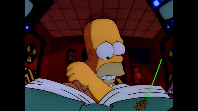 An animated Homer Simpson from The Simpsons reading a book in a dimly lit room with red lighting, featuring a small atom/nuclear symbol icon highlighted with a green arrow on the book's spine.