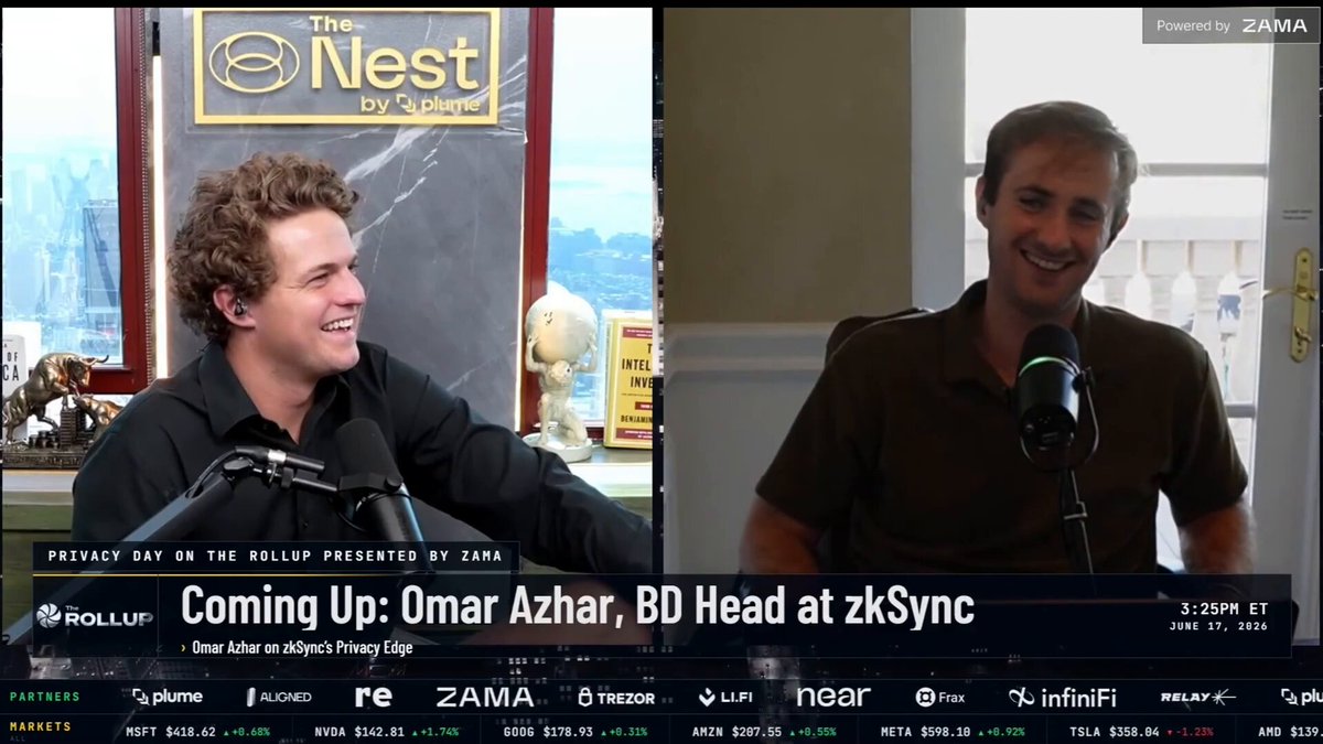 The image shows a television screen displaying an interview between two men sitting next to each other at a microphone. One man appears to be smiling while the other seems to be frowning or looking down, possibly engaged in a conversation about privacy concerns. The background of the image features a window and a teddy bear on a shelf, adding some context to the setting. The text "@therollupco" is also visible, indicating that this might be an interview with @therollupco.