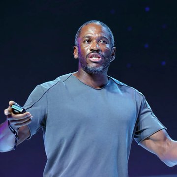 Arthur Hayes, the BitMEX co-founder and prominent crypto commentator, is shown mid-speech on stage delivering his views on market liquidity. His presence visually reinforces the quote, highlighting his role as a vocal advocate for liquidity-driven market analysis over headline noise.