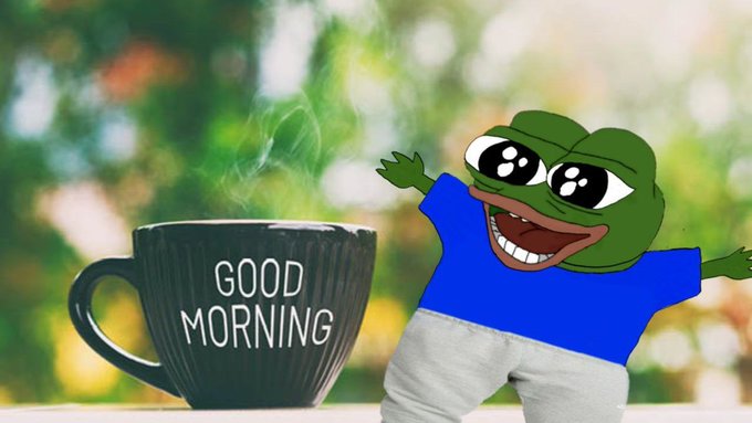 A 'Good Morning' meme featuring a Pepe the Frog character in a blue shirt next to a steaming coffee mug with a blurred green nature background.