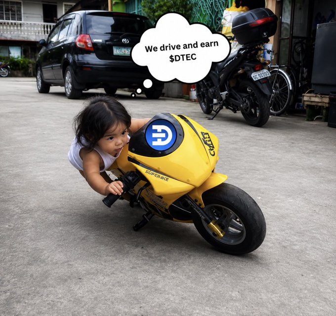 A child leaning on a miniature yellow motorcycle designed to look like the Ducati Superbike, with a thought bubble above reading 'We drive and earn $DTEC' and a DTec logo on the bike's front.