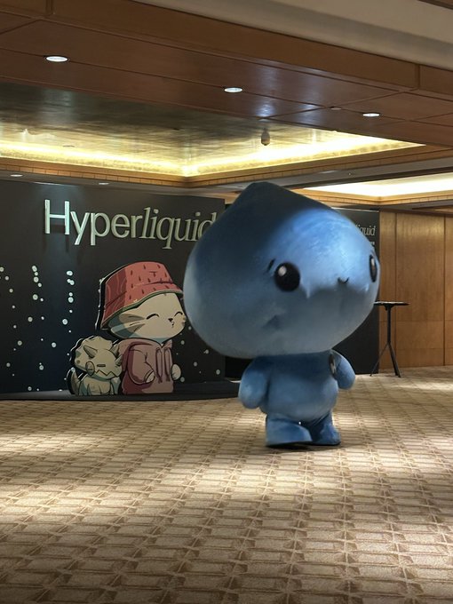 A blue mascot character from PiP (Pi Protocol) stands in front of a "Hyperliquid" branded backdrop at what appears to be a conference event in Singapore, illustrating the post's excitement about the cryptocurrency project expanding its presence beyond online spaces into real-world industry events.