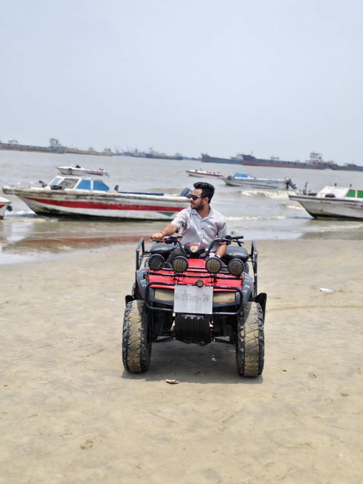 iced tea and a red sign with white text are present on the beach, while boats of various sizes float in the water beyond.