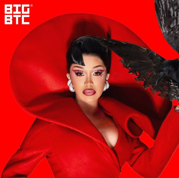 A woman in a bold red outfit poses dramatically with a black raven perched near her face against a vibrant red background, with a 'BIG BTC' logo in the top-left corner.