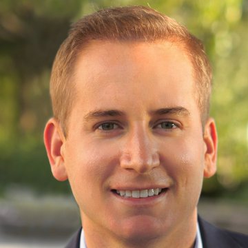 The image shows a smiling man with short blonde hair wearing a dark suit jacket and white shirt, posed against a softly blurred green background. This appears to be Robert Mitchnick, BlackRock's Head of Digital Assets, whose commentary on Bitcoin's decoupling from equities is referenced in the accompanying post.