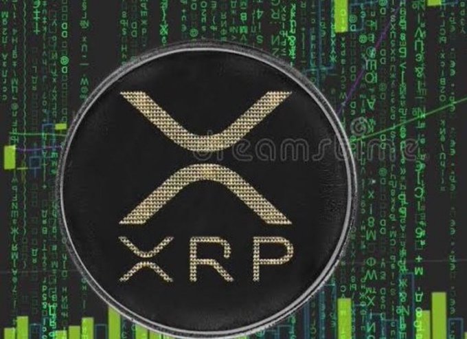 A physical representation of an XRP cryptocurrency coin sits prominently in the foreground, set against a backdrop of cascading green digital code and financial chart graphics. The image visually reinforces the post's speculative question about how many XRP tokens would be required to achieve millionaire status by 2026.