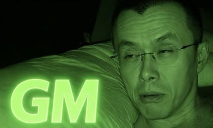 A man rests his head on a pillow bathed in green light, with the text "GM" displayed prominently in glowing green letters in the foreground, tying into the post's "GM BNB BUILDERS" theme—a common crypto greeting used to say "Good Morning" to the BNB (Binance Coin) community.