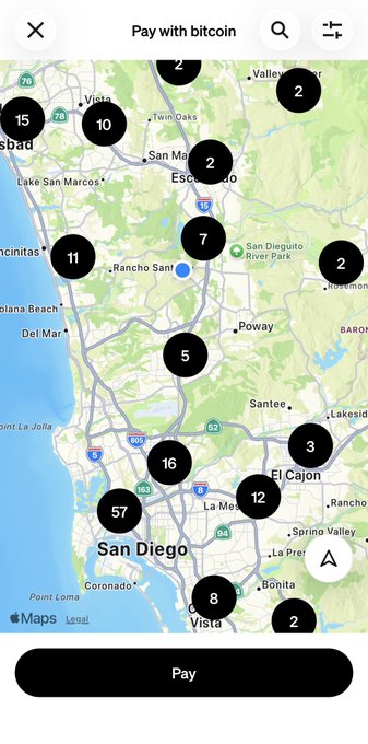 A 'Pay with bitcoin' map interface of the San Diego area displaying various Bitcoin ATM or merchant locations marked with numbered black circles containing values such as 57, 16, 15, 12, 11, 10, 8, 7, 5, 3, and 2.