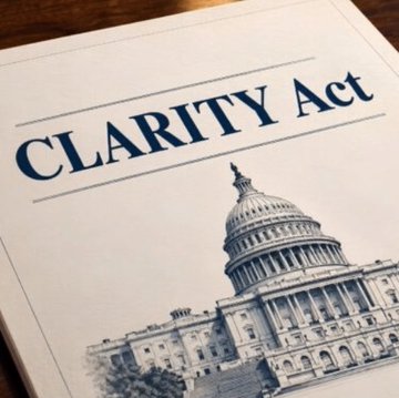 A document titled "CLARITY Act" rests on a wooden surface, featuring an illustration of the U.S. Capitol building—symbolizing the legislative push by 7 U.S. Senate Democrats to secure the bill's passage.