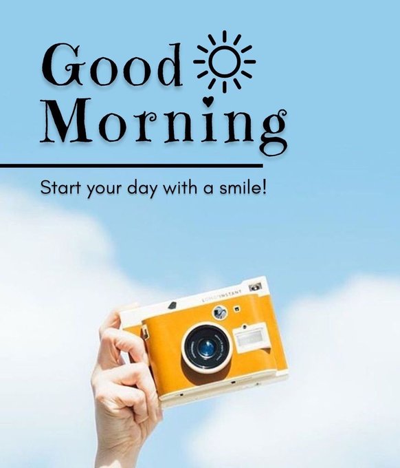 A 'Good Morning' greeting graphic with the text 'Start your day with a smile!' featuring a hand holding a yellow Lomo'Instant camera against a blue sky with clouds.