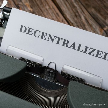 A typewriter with a piece of paper inserted, displaying the word 'DECENTRALIZE!' typed out, credited to '@watchemewsx'.