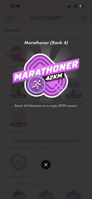 The image shows a phone screen displaying an achievement log for a marathoner named "Marathoner 42 km". The log includes badges for various achievements such as "clan", "ranking", and "reached 42 km". The text on the screen reads, "Achievement", which indicates that the runner has accomplished something significant in their marathon training.